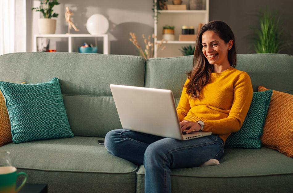 woman sitting on the sofa using her laptop computer