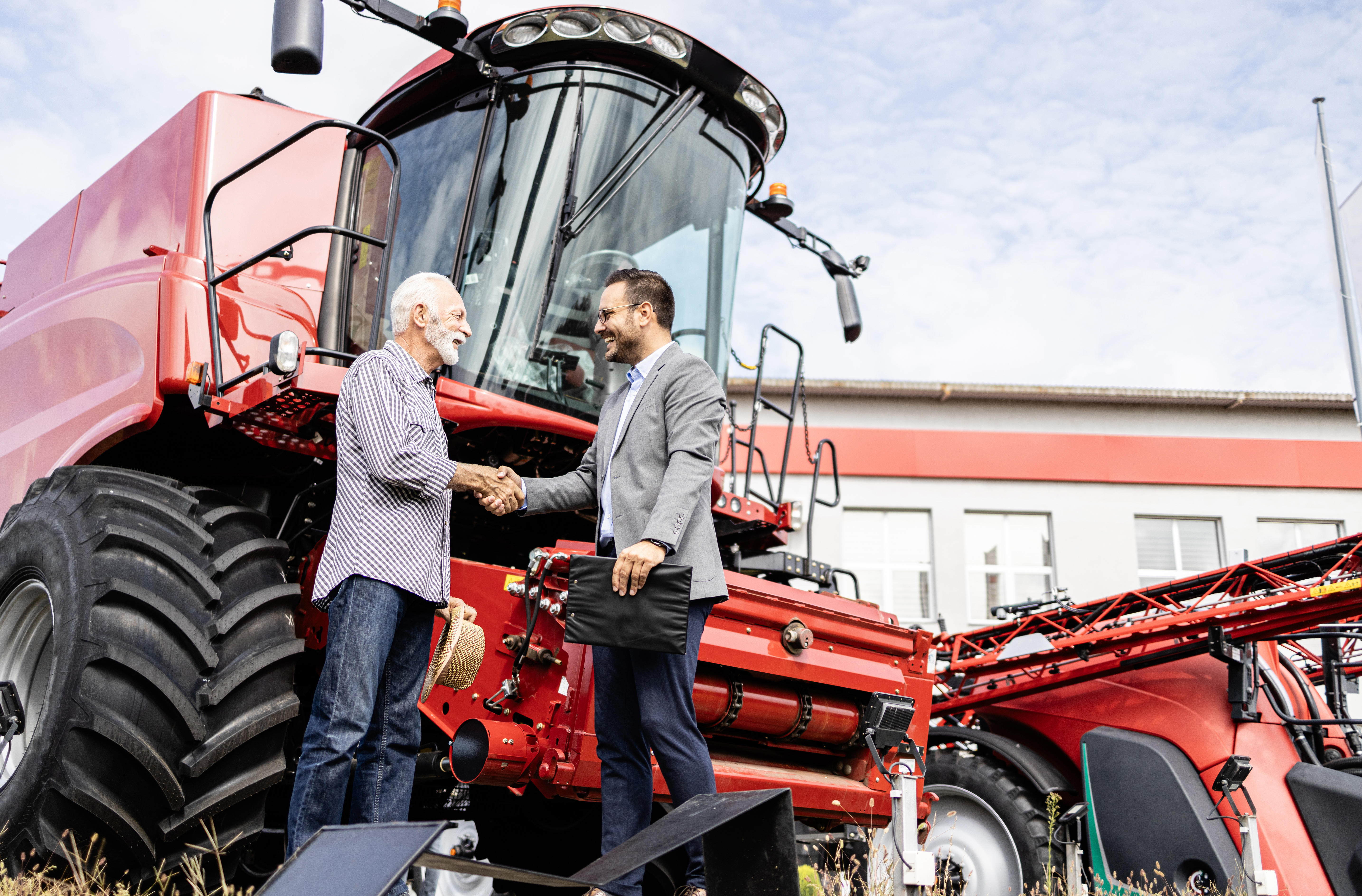 2 men standing in front of a combine