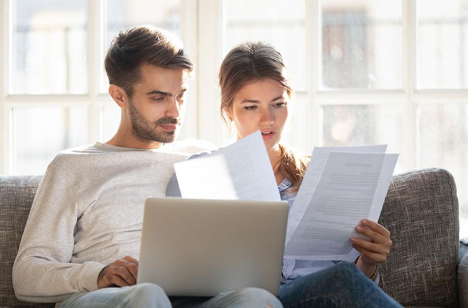 couple looking at papers and a laptop